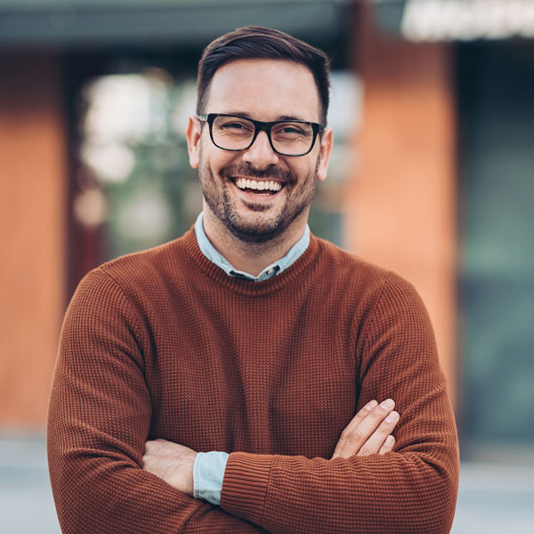 man smiling with his arms crossed