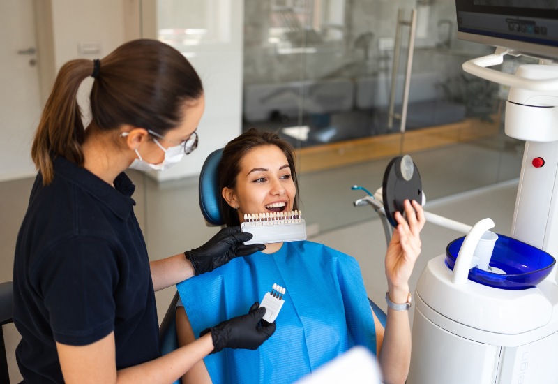 Patient reviewing tooth shade with dentist for dental veneers in Springboro, OH clinic