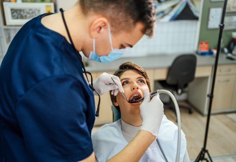 A dentist is performing root canal treatment on a patient in Fremont, IN
